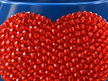 A close-up of a blue plant pot with a bright orange crystal heart in the centre. 