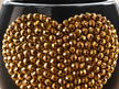 Close-up of The Golden Child black decorative ceramic planter with dark gold crystal heart detail