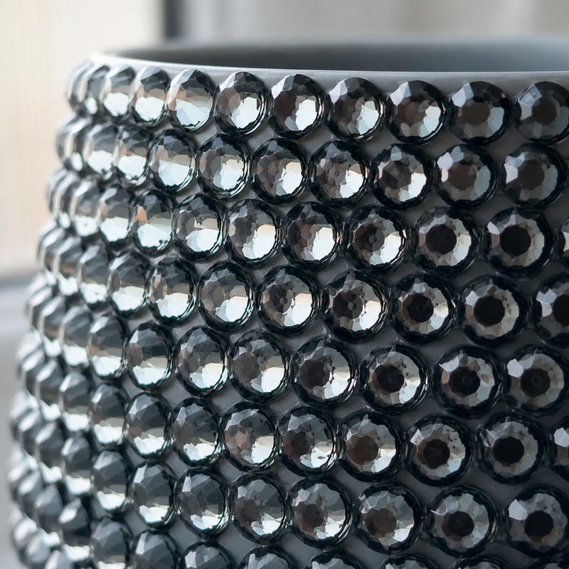 Close-up of a grey Moon Dust planter covered with faceted dark grey to black crystals, showing the reflective crystal texture in detail.