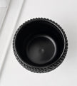 A black ceramic plant pot with a textured, beaded outer rim, shown from a top-down perspective on a clean white background.