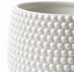 Close up shot of a white ceramic plant pot showing its textured surface and pearl accents. 