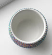 White ceramic plant pot decorated with iridescent crystals on a white background
